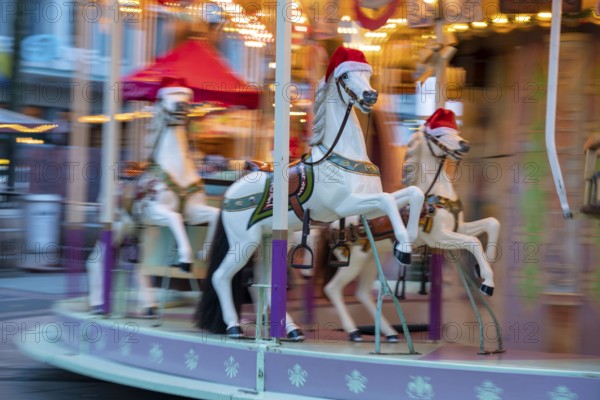 Pre-Christmas season, Christmas market on Kennedyplatz in the city centre of Essen, carousel, horses with Christmas hats, North Rhine-Westphalia, Germany, Europe