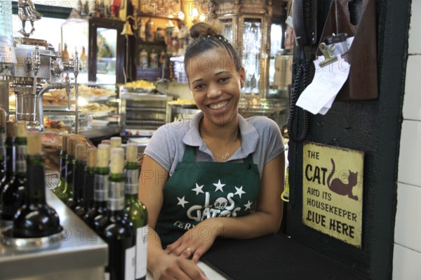 Smiling barmaid inside famous historic Los Gatos Cervecerias bar, Madrid city centre, Spain, Europe