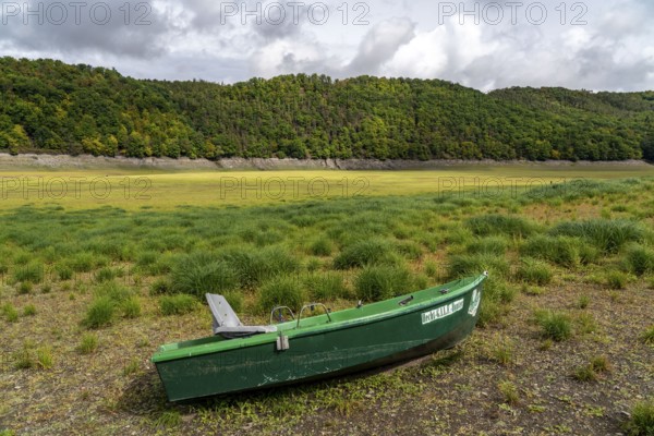 The Edersee, near Waldeck, the third largest reservoir in Germany, currently has only just under 13% of its normal level, the lake was last full in May 2022, dried up due to lack of rain, stranded fishing boat, pike hunter, the lake shore and the lake bottom is overgrown with fresh grass, Hesse, Germany, Europe