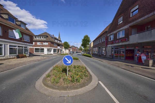 Traffic island with traffic sign for passing on the right on Weseler Strasse in Buldern, Dülmen, Münsterland, Coesfeld district, North Rhine-Westphalia, Germany, Europe