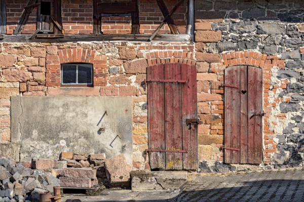 Historic farmhouse around 1800, half-timbered façade, sandstone, natural stone, brick, cement, weathered wooden doors to stable and loo, with heart, idyllic, romantic, Nidda, Vogelsberg, Wetterau, Hesse, Germany, Europe