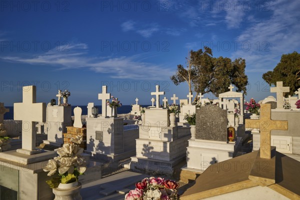 A peaceful cemetery with numerous white gravestones and crosses stretching down to the sea, Agios Nikolaos church, cemetery, Pigadia, town and harbour, Pigadia Bay, main town, Karpathos, Dodecanese, Greek Islands, Greece, Europe