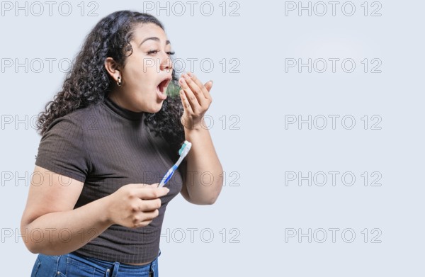 Young woman holding brush with bad breath isolated. Person with brush and bad breath isolated, Person with halitosis