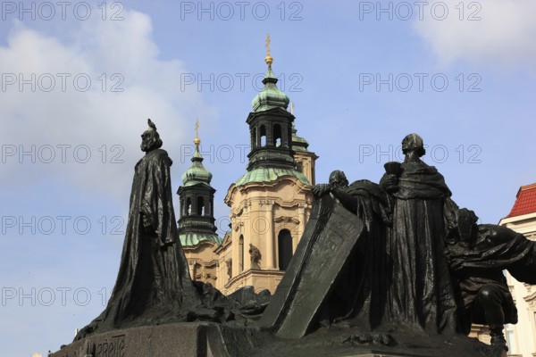 Jan Hus Monument on the Old Town Square and the towers of St Nicholas Church, Prague, Czech Republic, Europe