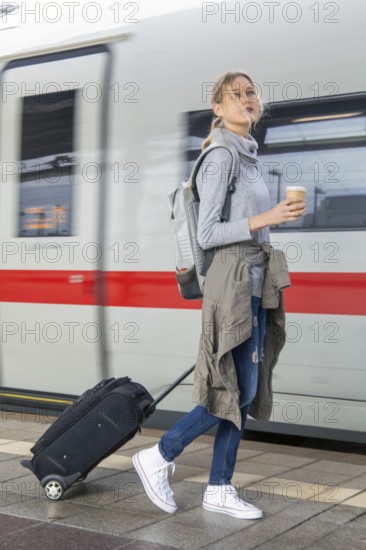 Young woman on the railway track while a train arrives