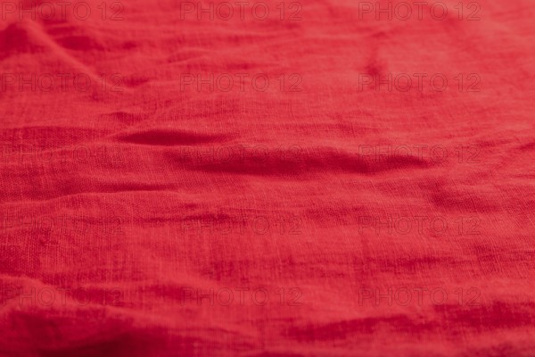 Fragment of smooth red linen tissue. Top view, flat lay, natural textile background and texture