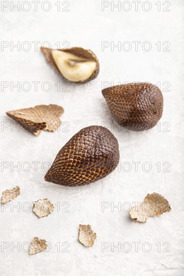 Salak or snake fruit on gray concrete background. Side view, close up, selective focus. Tropical, healthy food, summer, exotic, minimalism