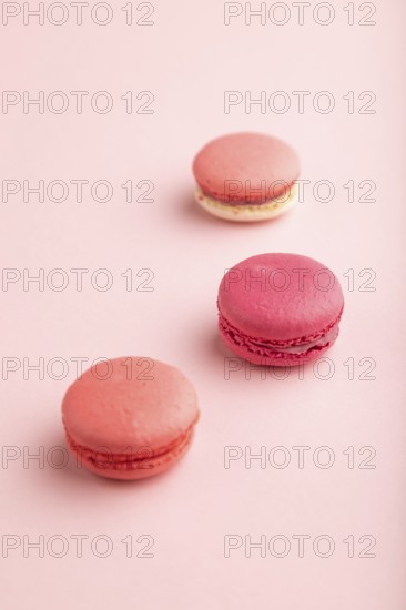 Purple and pink macaroons on pink pastel background. side view, close up, still life, selective focus. Breakfast, morning, easter concept