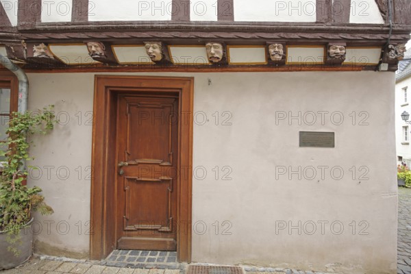 Half-timbered house with seven envious heads and wood carvings, envious head, grimace, faces, front door, wooden door, wooden figures, house of the seven vices, Brückenstraße, old town, Limburg, Hesse, Germany, Europe