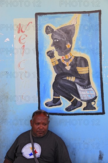 South Ethiopia, in Dimeka, local man sitting in front of a painting in a cafe, Ethiopia, Africa