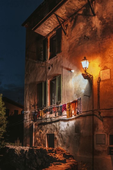 Dilapidated house wall with clothesline, house, evening mood, evening, urban, atmospheric, light, light mood, lighting, lamp, tourism, Italy, Europe