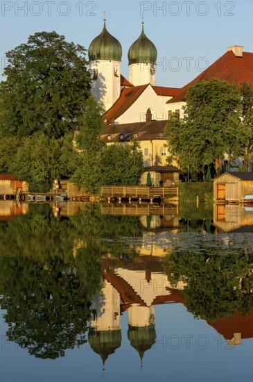 Romanesque Benedictine Abbey Seeon Monastery, monastery church St. Lambert with reflection in the monastery lake, calm smooth water in the evening light at sunset, Seeon-Seebruck, Chiemgau, Upper Bavaria, Bavaria, Germany, Europe