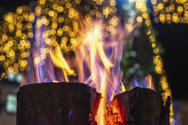 A log with glowing orange-coloured flames on it. The fire is surrounded by a blurry-coloured background, which gives the impression of a warm and cosy atmosphere. The flames seem to dance and flicker. Bas rhin, Alsace, France, Europe