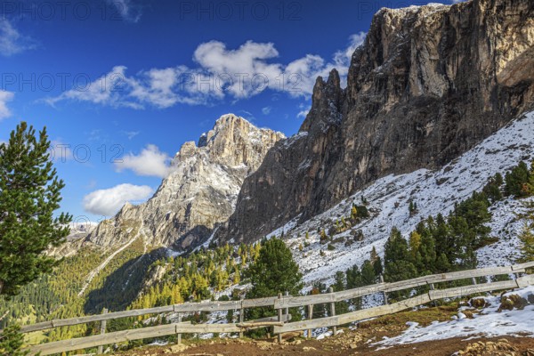 The rocky Sella Group mountain landscape in the South Tyrolean mountains with a wooden fence and snow, South Tyrol, Italy, Europe