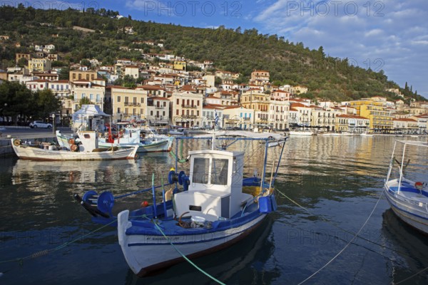 Small fishing boats in the Mediterranean harbour of Gythio or Gythion, behind houses and the Taygetos Mountains, Mani Peloponnese, Greece, Europe