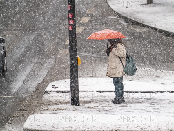 Winter weather, heavy snowfall, city centre traffic, Alfredstraße, B224, in Essen, person with umbrella waiting at traffic lights in snowstorm, North Rhine-Westphalia, Germany, Europe