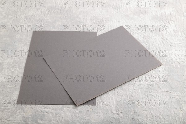 Gray paper business card, mockup on gray concrete background. Blank, flat lay, top view, still life, copy space