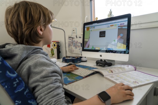 Young, primary school pupils, home learning, doing schoolwork, distance learning, virtual classroom, at home on the computer, effects of the corona crisis in Germany