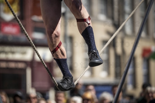 Feet balancing on a tightrope, street artists performing high-wire acrobatics, world's largest cultural festival The Fringe, High Street, Edinburgh, Scotland, United Kingdom, Great Britain, Europe