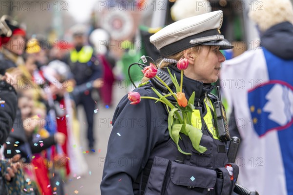 Rose Monday parade in Düsseldorf, policemen on duty at the street carnival, with flower decorations, given by the parade participants, North Rhine-Westphalia, Germany, Europe