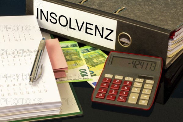 Symbolic image of insolvency: folders, calculators and euro banknotes