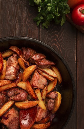 Ojakhuri, Traditional Georgian dish, fried potatoes with meat, in a clay frying pan, top view, no people, homemade