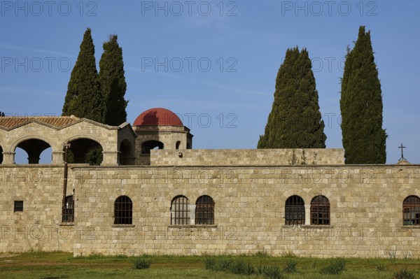 Monastery of Our Lady of Mount Filerimos, Historic stone wall with round windows and tall cypresses in the background on a clear day, Filerimos, hill not far from Rhodes Town, Ancient State of Ialyssos, Rhodes, Dodecanese, Greek Islands, Greece, Europe