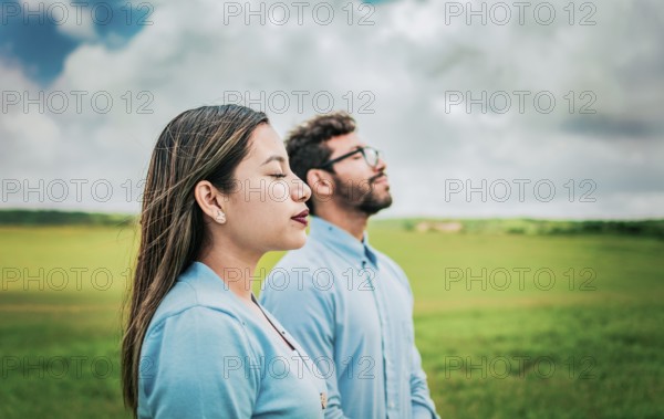 Young couple breathing fresh air in the field. Two relaxed people breathing fresh air in the field