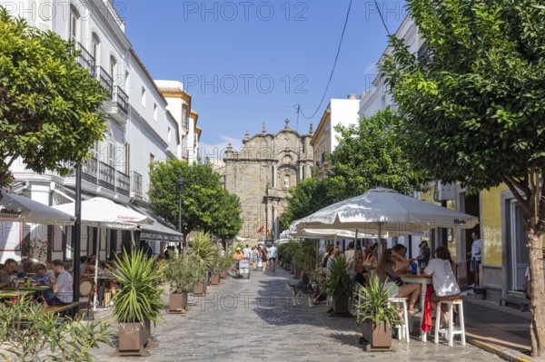 Lively pedestrian zone with cafés and plants in bright sunshine, Tarifa