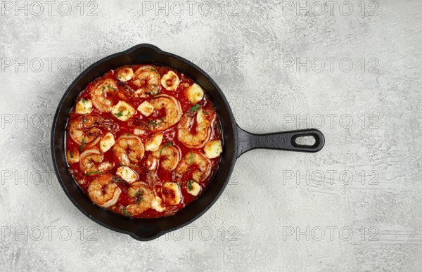 Greek saganaki, in an iron pan, saganaki with shrimp, shrimp in tomato sauce, with pepper and feta cheese, homemade, no people