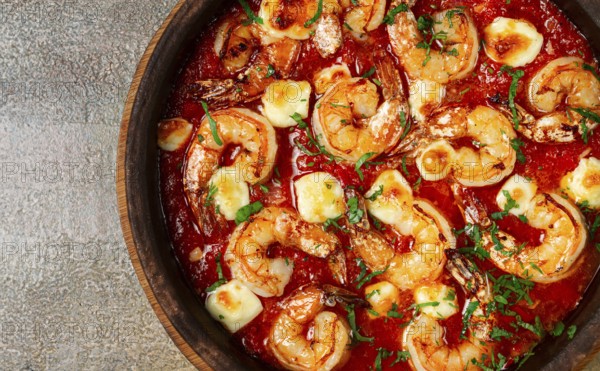 Saganaki with shrimp, in a clay pan, Greek dish, shrimp in tomato sauce, feta cheese, homemade, no people