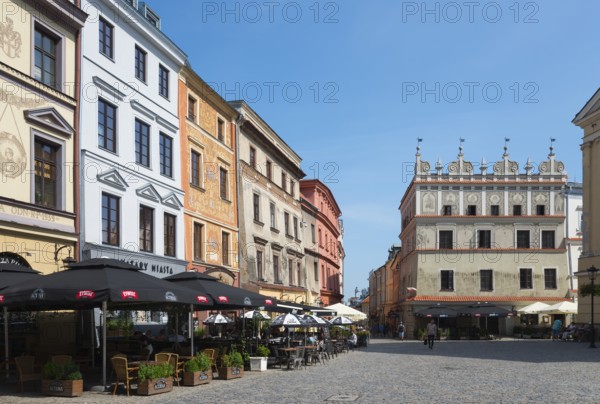 Town square with historic facades and street cafés under a blue sky, Chociszewska tenement house, Old Town, Lublin, Poland, Europe