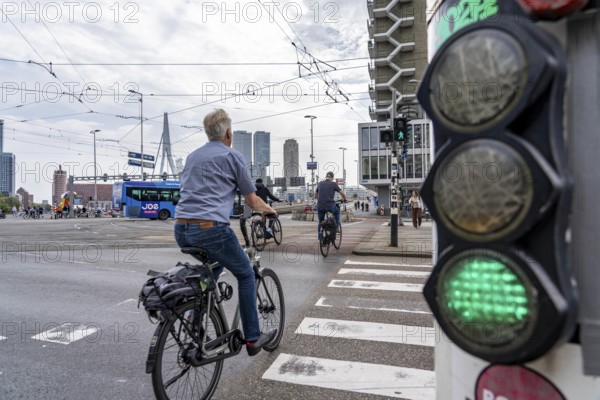 Bicycle traffic light, cyclist on cycle path, in front of the Erasmus Bridge over the Nieuwe Maas, skyline of skyscrapers on the Kop van Zuid, Rotterdam, Netherlands