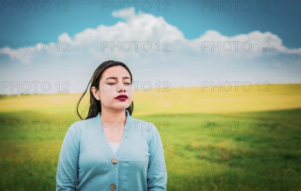 Relaxed girl breathing fresh air in the field. Close up of relaxed woman breathing fresh air in the field