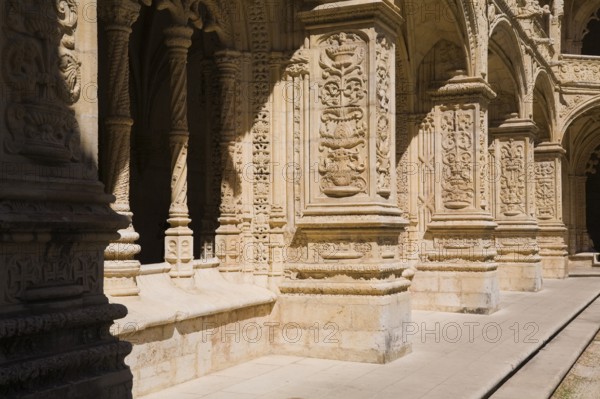 Old building with columns and arches decorated with architectural details in the inner courtyard at Jeronimos Monastery, Lisbon, Portugal, Europe