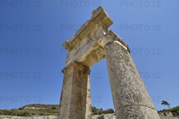 Stone ancient column rises under a clear blue sky, Kamiros, Archaeological site, Ancient city, Foundation of Doric Greeks, Rhodes, Dodecanese, Greek Islands, Greece, Europe