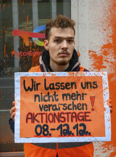 Last Generation activist after colour attack on Total Energies building. They are protesting against the World LNG Summit, which is due to take place in Berlin in December. On the poster: We will not be fooled anymore! Days of action 08-12 December! Berlin, 06.11.2024