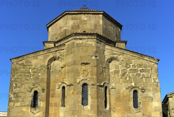 East façade of the Dzhvari Cross Church with three architectural bas-reliefs depicting the church founders Christ and Stephen I, centre, brothers Demetrius, right, and Adarnerse, left, above the apse windows, Dzhvari Monastery, UNESCO World Heritage Site near Mtskheta, Georgia, Asia