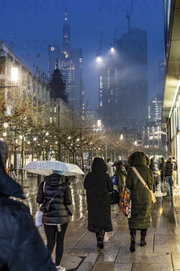 Rainy weather, freezing rain, pedestrian zone Zeil, shopping street, high-rise skyline in clouds, passers-by hurrying through the damp, icy weather, Frankfurt am Main, Hesse, Germany, Europe