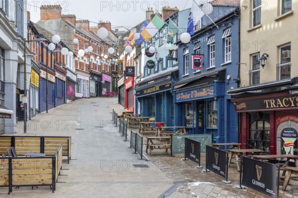 Empty city street with cafés and colourful buildings full of flags and fairy lights, Letterkenny