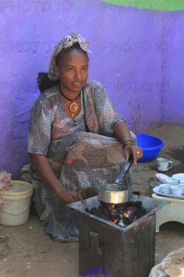 In the highlands of Abyssinia, in the village of Sina, young woman roasting coffee for the coffee ceremony, Ethiopia, Africa