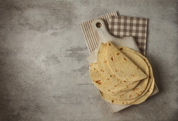 A stack of Mexican tortillas, on a gray table, top view, close-up, no people