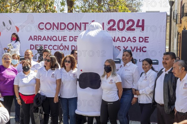 Oaxaca, Mexico, Health workers pose for photos with a person wearing a condom costume as part of their campaign against sexually-transmitted diseases. Afterwards, they walked the streets, handing out free condoms, Central America