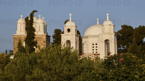 White church with three domes and bell towers, surrounded by greenery under a clear sky, Koroni, Byzantine fortress, nunnery, Peloponnese, Greece, Europe