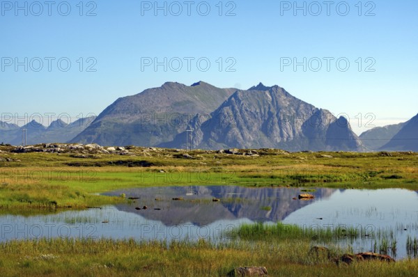 A peaceful natural landscape with a mountain and a lake reflecting the surrounding rocks and sky, boggy landscape, silence, tranquillity, Lofoten, Norway, Europe