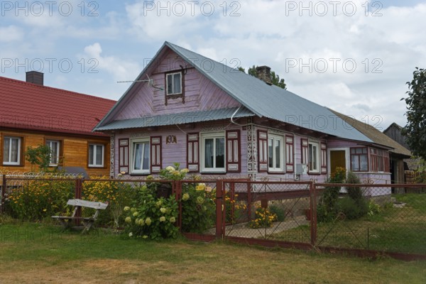 Wooden house with red roof in a rural setting, surrounded by garden and flowers, Wojszki, Bialystok, Bialystok, Bjelostock, Podlaskie, Poland, Europe