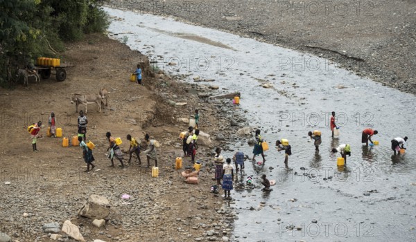 Women and girls fetch water in plastic canisters from a river near the road from Arba Minch to Konso, southern Ethiopia