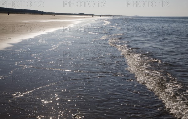 Contre jour waves reaching a sandy beach at Holkham, north Norfolk coast, England, United Kingdom, Europe