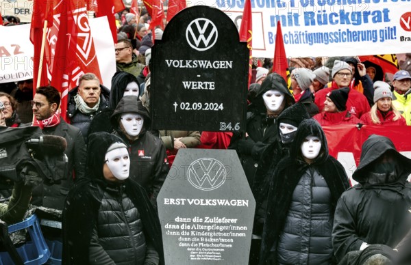 A symbolic VW coffin is carried by Volkswagen employees to the collective bargaining negotiations of Volkswagen and IG Metall in front of the Volkswagen Arena in protest against plant closures and redundancies, Wolfsburg, 21 November 2024, Wolfsburg, Lower Saxony, Germany, Europe