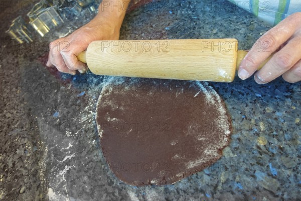 Swabian cuisine, Swabian Christmas biscuits, preparation of cookie cutters, shortcrust biscuits, rolling out raw dough with cocoa, rolling pin, typical Swabian, baking, Christmas biscuits, sweet biscuits, Gutsle, Bredle, baked goods, from the oven, men's hands, traditional cuisine, food photography, studio, Germany, Europe